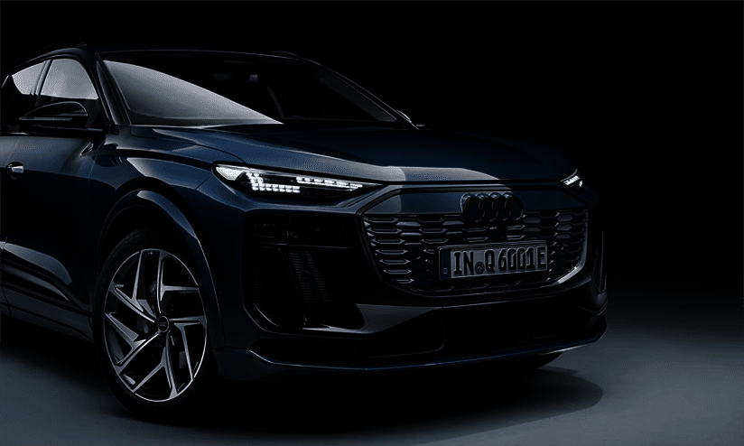 Dunkelblauer Audi Q6 SUV e-tron vor dunklem Hintergrund